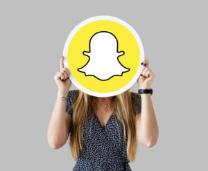 women showing a snap chat icon for how to create snapchat ads