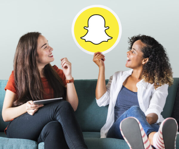 Woman holding emoticons on a couch